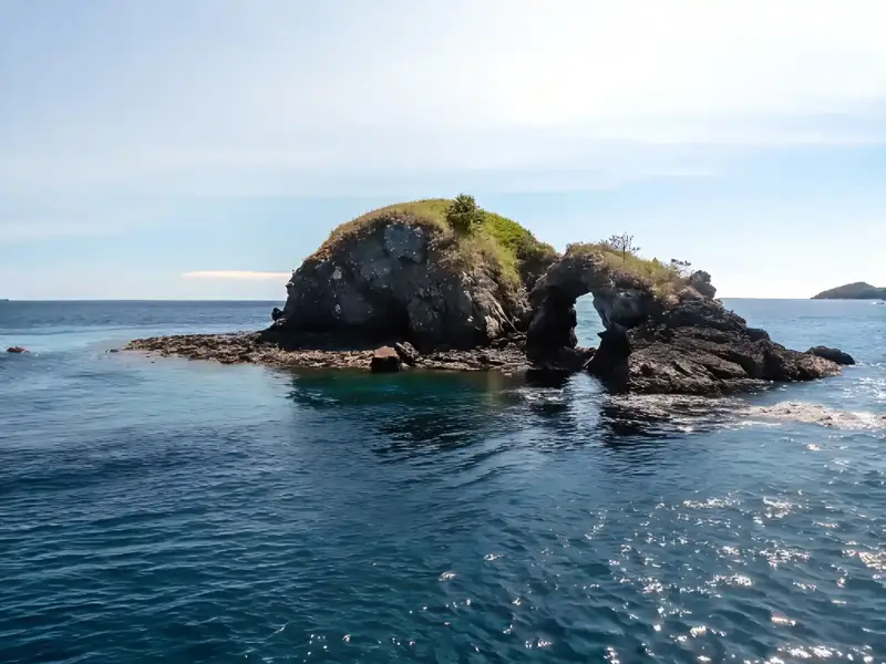 The Batu Bolong pinnacle above the water
